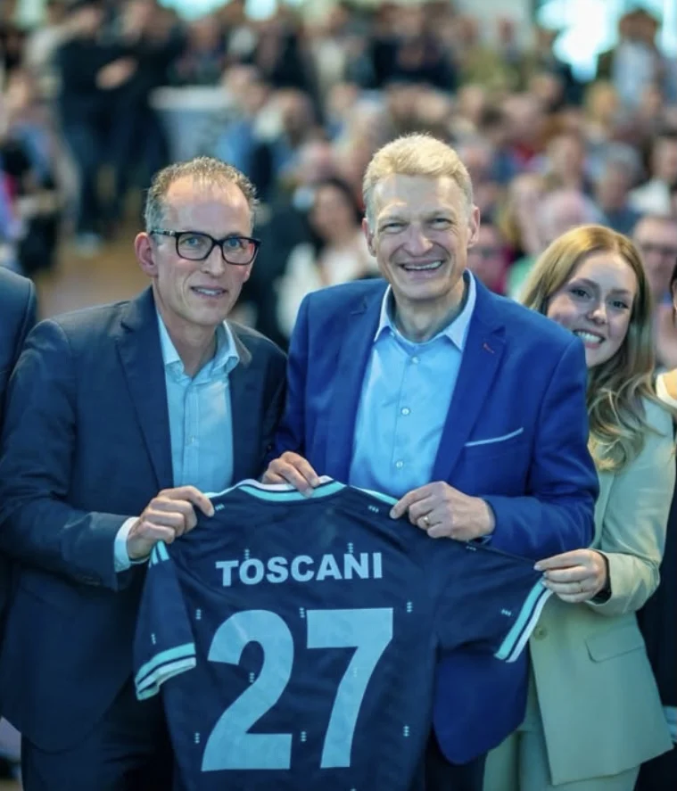 Stephan Toscani hält ein Trikot mit der Aufschrift „Toscani 27“, umgeben von Unterstützern bei einer Veranstaltung der CDU Saar.
