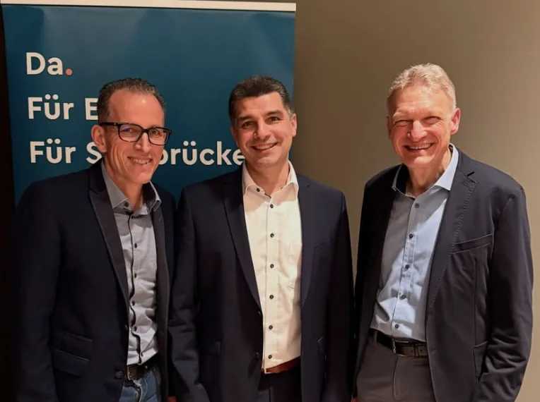 Christian Müller (Mitte) mit Frank Wagner und Stephan Toscani vor dem Banner „Da. Für Euch. Für Saarbrücken.“